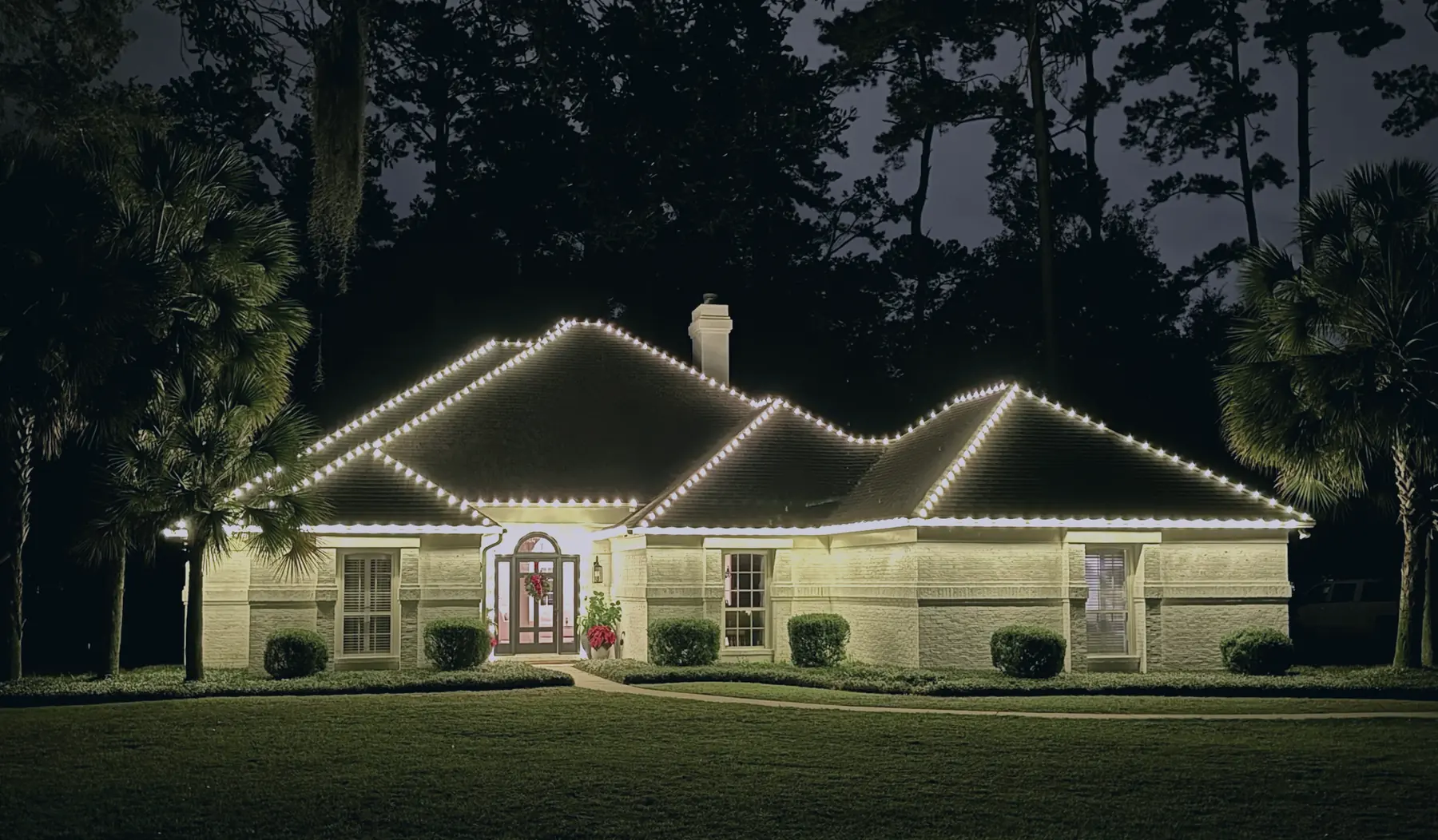 Warm white Christmas lights along a Tallahassee roofline with wrapped porch columns